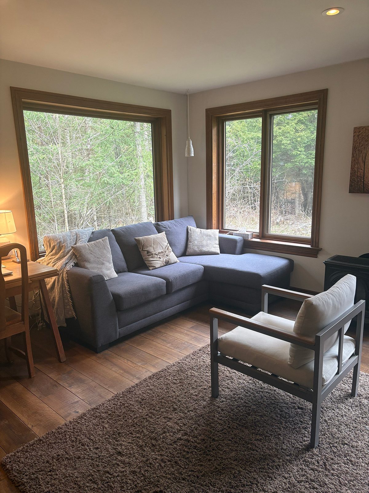 A corner sofa and armchair arranged in a warm therapy space.